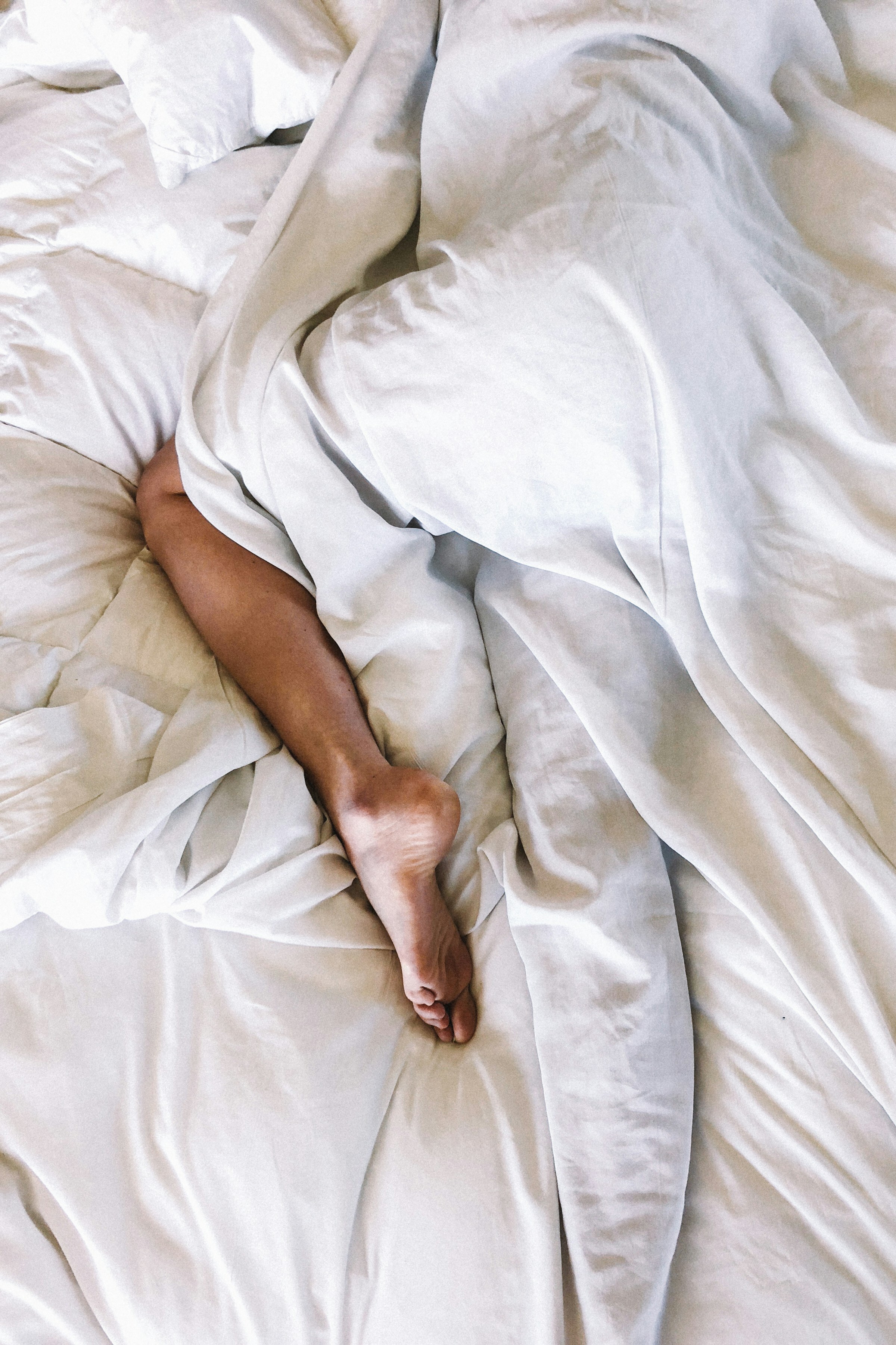 man and woman sleeping in a white bed | Photo by DANNY G on Unsplash